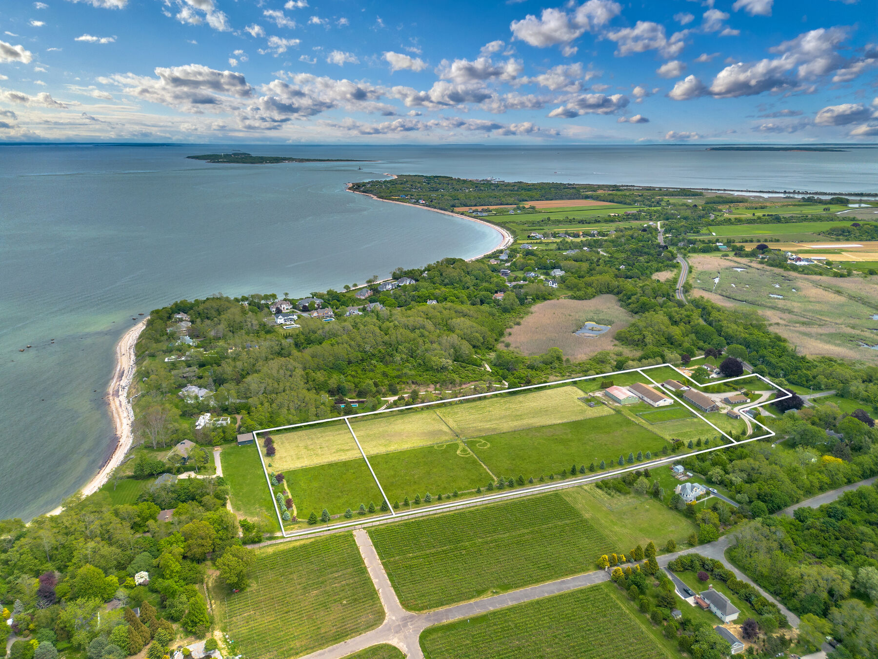 Wide aerial showing the estate, the bay, and surrounding farmland