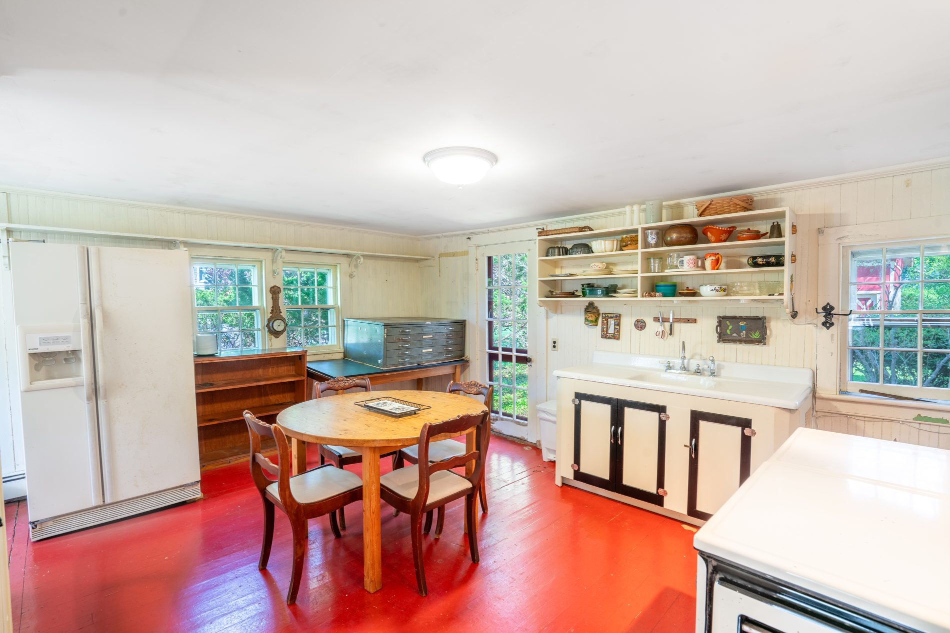 A second view of the cottage interior with built-in cabinetry and windows