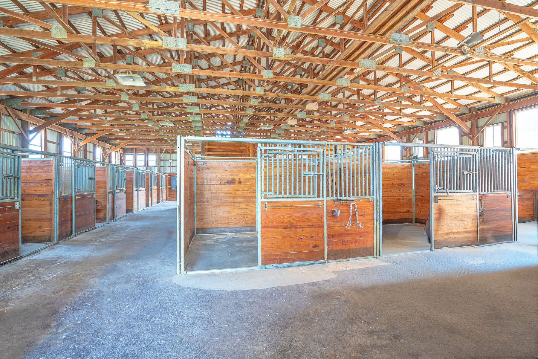 The 20-stall stable interior with hand-built wood beam ceiling