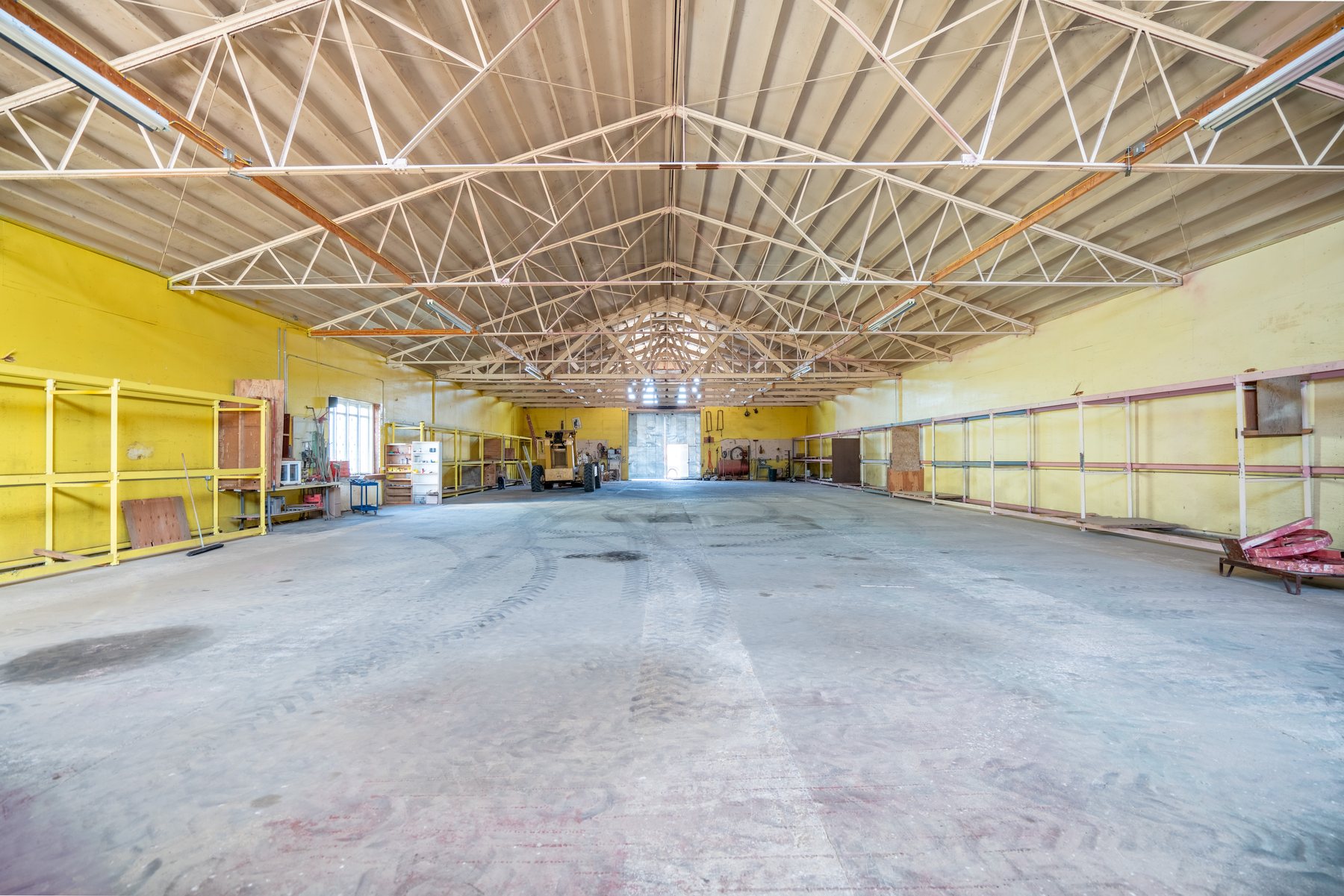 Riding arena interior cleared, looking the full 135-foot length to the open bay door